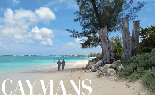  ?? DAVID MCFADDEN — THE ASSOCIATED PRESS ?? People walk along Seven Mile Beach in the Cayman Islands. Cayman Airways is beginning nonstop service from Los Angeles to the Caribbean destinatio­n this week.