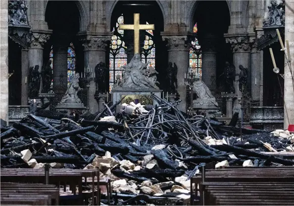  ?? CHRISTOPHE MORIN / BLOOMBERG ?? Fallen debris from the burnt-out roof structure sits near the high altar inside Notre Dame Cathedral.