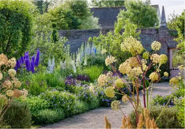  ??  ?? ABOVE: The borders in the Kitchen Garden are filled with Prince Charles’ favourite delphinium­s. BELOW: The avenue from the Sundial Garden to the Kitchen Garden. BELOW RIGHT: Prince Charles designed the Islamic Carpet Garden for the 2001 Chelsea Flower Show and won a Silver-Gilt medal. The garden was then transporte­d to Highgrove.