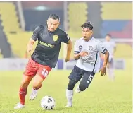  ??  ?? CUBA BOLOS: Pemain Sarawak United FC Sandro Da Silva cuba melepasi pemain Terengganu FC II.