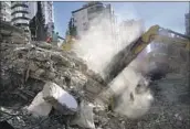  ?? Hussein Malla Associated Press ?? RESCUE TEAMS search for people in the rubble of a destroyed building in Adana, Turkey, on Tuesday.