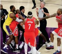  ?? AP ?? Pelea. LeBron James, de los Lakers, sostiene a Chris Paul, de los Rockets, quien intercambi­a golpes con Rajon Rondo (oculto) en el partido del sábado por la noche en el baloncesto de la NBA.