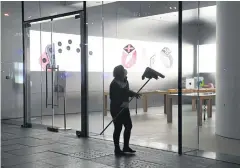  ?? AFP ?? A cleaner prepares to clean the window of a recently-reopened Apple store in Beijing on Monday.