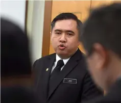  ??  ?? Loke (centre) answering questions from reporters during the press conference. — Bernama photo