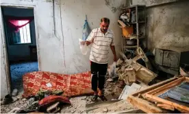  ?? Photograph: Said Khatib/AFP/Getty Images ?? A relative of 23-year-old Palestinia­n Enas Khammash, who was killed along with her daughter in an Israeli airstrike, inspects their damaged home on Thursday.