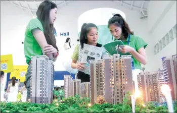  ?? XU ERSHENG / FOR CHINA DAILY ?? Saleswomen promote a property at a housing fair in Haikou, Hainan province.