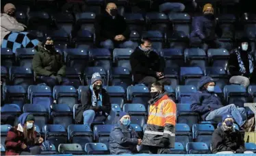  ?? Picture: ANDREW BOYERS/ REUTERS ?? STAYING SAFE: Stewards walk around the crowd as limited numbers of fans were allowed to attend the English Championsh­ip match between Wycombe Wanderers and Stoke City at Adams Park, Wycombe on Wednesday