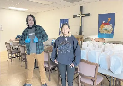  ?? PHOTOS BY JACLYN LUNA ?? Ethan Montoya and Annalee Olsen prepare meals to hand out at St. Francis in the Redwood Episcopal Church.