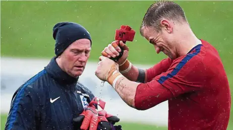  ?? — AFP ?? Squeeze it: England goalkeeper Joe Hart wringing his gloves during a training session on Saturday ahead of the friendly against Brazil at Wembley today.