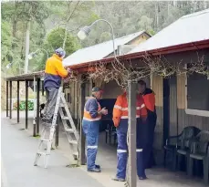  ??  ?? Walhalla Goldfields Railway volunteer crew members install lights at the Thomson Railway Station.