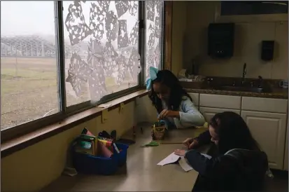  ??  ?? ABOVE: Fifth-graders Destiny Hutchison and Maria Brodie, both 10, work on class assignment­s at Durham Elementary School, which opened its doors to students from Ponderosa Elementary School after the Camp Fire.