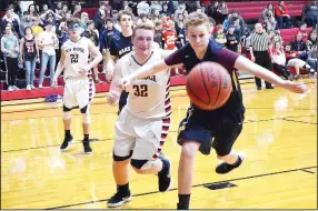  ?? TIMES photograph by Annette Beard ?? Junior Blackhawk Mikey Mahoney, No. 32, races against a Haas Hall defender to retrieve the basketball Friday night in Blackahwk Gym. The ’Hawks defeated the Haas Hall Mastiffs 57-44.