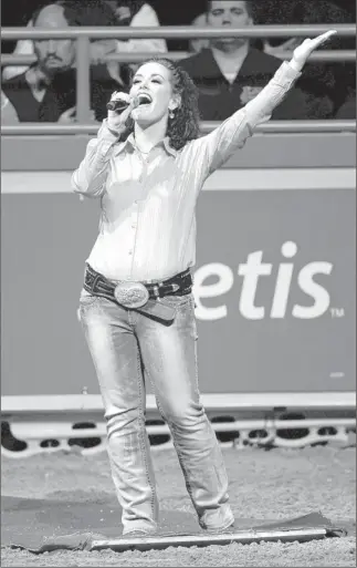  ?? DAVID BECKER/ LAS VEGAS REVIEU-JOURNAL ?? Television host Jackie Schmillen from Des Moines, Iowa, sings the national anthem before the fourth round at the National Finals Rodeo on Sunday at the Thomas & Mack Center.