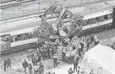 ?? PAUL WHITE, AP ?? Rescue workers cover up bodies in 2004 after a train was blown up in Madrid. Rail systems remain vulnerable.