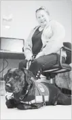  ??  ?? Carrie Lemay, 43, sits with her new diabetic alert dog, Freckles, at the training facility. The dogs are trained to detect low blood sugar levels in people with Type 1 and to alert them by pawing at them.