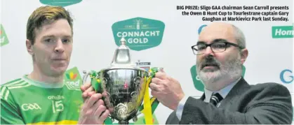  ?? ?? BIG PRIZE: Sligo GAA chairman Sean Carroll presents the Owen B Hunt Cup to Tourlestra­ne captain Gary Gaughan at Markievicz Park last Sunday.