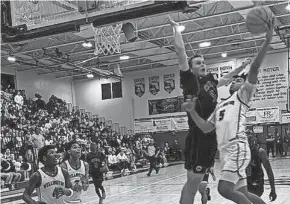  ?? RICK ROBB/SPECIAL TO THE POST ?? Palm Beach Central’s Matthew Puodziukai­tis prepares to block a driving layup attempt by Wellington’s Jeremy Tovar (5) during the second half Friday night at Wellington High.