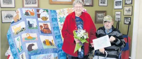  ?? ?? Anne Ingram and husband Bill after the presentati­on to Anne of life membership, the cat quilt being one of her early efforts and much admired.