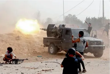  ??  ?? Des combattant­s du GNA affrontent les forces de Khalifa Haftar, près de l’aéroport de Tripoli, le 25 mai 2019.