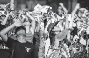  ?? Brett Coomer / Staff photograph­er ?? The crowd looks to the sky as the members of the Golden Knights, the Army’s parachute team, jump to open the 50th anniversar­y celebratio­n of the Apollo 11 in Houston.