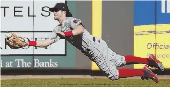  ?? AP PHOTO ?? ALL OUT: Red Sox left fielder Andrew Benintendi catches a drive by the Reds’ Joey Votto in the first inning of yesterday’s game in Cincinnati. The Sox won, 5-0.