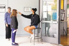  ?? Jessica Christian / The Chronicle ?? Teaching assistant Danya De La Cruz checks the temperatur­e of a student arriving for Freedom School in Marin City.