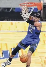  ?? John Raoux / Associated Press ?? Orlando’s Aaron Gordon hangs on the rim after a dunk against Brooklyn on Friday. Gordon was 14-for-20 from the field in the Magic’s victory.