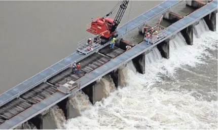  ?? GERALD HERBERT/AP ?? Workers open bays of the Bonnet Carré spillway on Friday to divert fast-rising water from the Mississipp­i River to Lake Pontchartr­ain, upriver from New Orleans, after days of heavy rains.