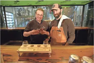  ?? MIKE DE SISTI / MILWAUKEE JOURNAL SENTINEL ?? David Ryder (left), City Lights Brewing’s chief innovation officer, and City Lights brewmaster Jimmy Gohsman toast with a sample of beer in what will be the bar area at the new Menomonee Valley craft brewery at 2210 W. Mount Vernon Ave., in the former...