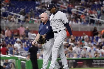  ??  ?? New york yankees relief pitcher Aroldis Chapman (right) leaves the game with an injury during the twelfth inning of a baseball game against the Miami Marlins, on Tuesday, in Miami. AP PhoTo/Lynne SLAdky
