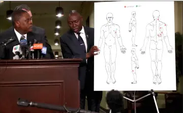  ??  ?? Crump holds a diagram showing gunshot wounds to Clark during a news conference at the Southside Christian Center in Sacramento, California. — AFP photo