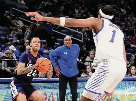  ?? Charles Rex Arbogast/Associated Press ?? UConn’s Jordan Hawkins (24) eyes the basket as DePaul head coach Tony Stubblefie­ld and Javan Johnson watch on Tuesday night in Chicago.