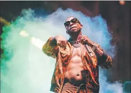  ??  ?? NO SHIRT, NO PROBLEM: Gucci Mane is commanding as he cycles through boisterous hip-hop tracks. The rapper’s slick set felt perfunctor­y, critic writes.