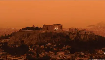  ?? Bild: Costas Baltas/Andalou/picture alliance ?? Der Staubsturm färbte die Stadt Athen samt Akropolis rot