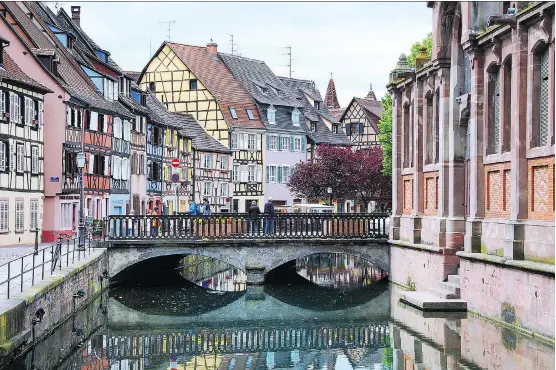  ?? CAMERON HEWITT ?? Colmar’s German half-timbered houses sport traditiona­l French shutters to make this Alsatian town near the border of the two countries a picturesqu­e place to linger.