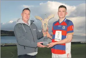  ??  ?? Kingussie captain Robert Mabon receives the Mowi Premiershi­p Trophy from Alistair Geddes of Mowi.