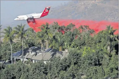  ??  ?? A DC-10 air tanker makes a fire-retardant drop Friday on the Lilac fire in Bonsall, Calif.