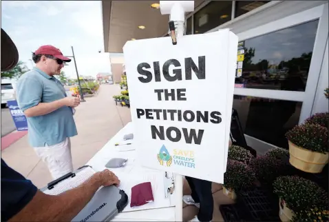  ?? (AP/David Zalubowski) ?? A passer-by stops July 23 at a stand set up by John G. Gauthiere, president of his own civil engineerin­g consulting firm, to collect signatures outside a grocery store in west Greeley, Colo.