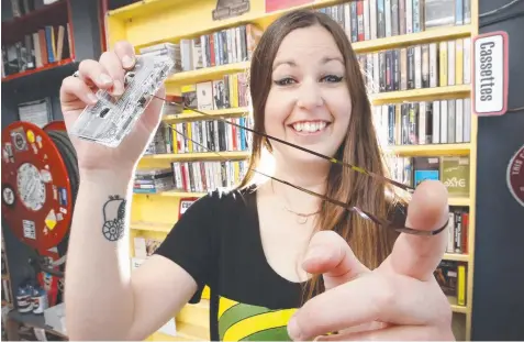  ?? Picture: DAVID CAIRD ?? GOING RETRO: Sales assistant Claire Birchall with cassette tapes in stock at Dixon’s Recycled Records in Melbourne.