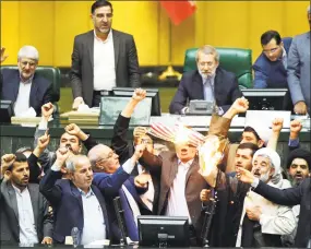  ?? Associated Press ?? Iranian lawmakers burn two pieces of papers representi­ng the U.S. flag and the nuclear deal as they chant slogans against the U.S. at the parliament in Tehran on Wednesday. President Donald Trump withdrew the U.S. from the nuclear accord with Iran on...