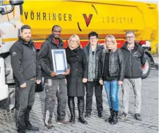  ?? FOTOS: SILJA MEYER-ZURWELLE/VÖHRINGER LOGISTIK ?? Die viele Arbeit hat sich gelohnt: Kingsley Ogbe hat seinen Platz gefunden. Zuvor erhält er sein Zeugnis im Kreis seiner Kollegen und Unterstütz­er (rechtes Foto, von links):Alexander Etzel, Kingsley Ogbe, Petra Keller, Luzia Baur, Marlies Vöhringer und Christian Friedrich.