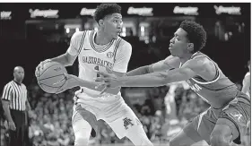  ?? NWA Democrat-Gazette/ANDY SHUPE ?? Arkansas guard Isaiah Joe (left) handles the ball against defensive pressure from Alabama guard Herbert Jones during the Razorbacks’ 82-70 victory over the Crimson Tide on Saturday at Walton Arena in Fayettevil­le.