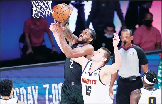  ??  ?? Los Angeles Clippers forward Kawhi Leonard (2) grabs a rebound over Denver Nuggets center Nikola Jokic (15) during the first half of an NBA conference semifinal playoff basketball game on
Sept 15, in Lake Buena Vista, Fla. (AP)