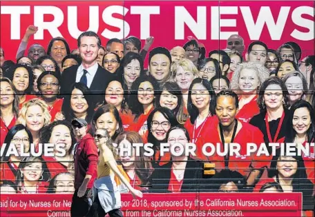  ?? Kent Nishimura Los Angeles Times ?? GAVIN NEWSOM, the front-runner in the governor’s race, has promised to pursue a state-supported single-payer healthcare system if he’s elected. Democratic rivals have called him fiscally reckless for backing a California program. Above, a bus ad...