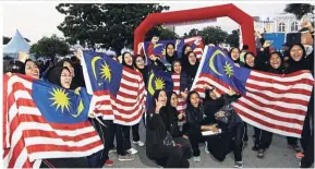  ??  ?? Malaysian pride: ( Top) Participan­ts getting ready to set off during the state-level Kembara Merdeka Jalur Gemilang convoy which was flagged off at St Xavier’s Institutio­n. (Bottom) A group of students participat­ing in the Merdeka Run at the Esplanade...