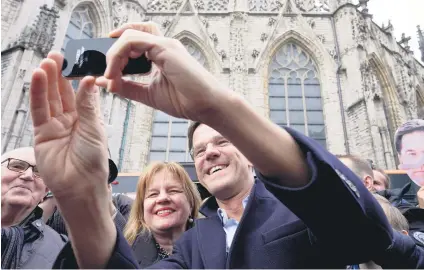  ?? Picture: AFP ?? UNITED WE STAND. Dutch Prime Minister and leader of the People’s Party for Freedom and Democracy Mark Rutte takes a selfie picture with a woman in Breda on Saturday.