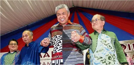  ??  ?? Hand in hand: Dr Ahmad Zahid raising the hands of Masir Kujat (second from left) and Douglas Uggah Embas in a show of solidarity during the event in Sri Aman. Looking on (left) is Nur Jazlan Mohamed.