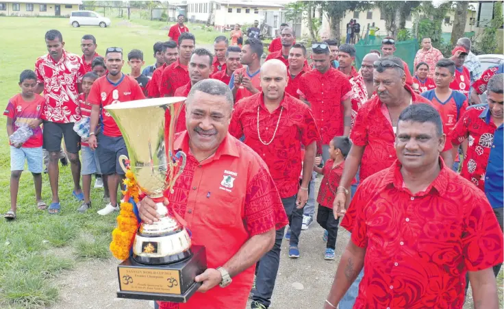  ?? Photo: Ronald Kumar ?? Tui Namosi Ratu Suliano Matanitobu­a with the Sanatan World Cup 2018 Trophy won by Navua Sanatan football team followed by team manager Vijay Prasad (right) and fans as they celebrate their win at Rampur College, Navua on September 15, 2018.