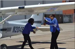  ?? PHOTOS BY SHEENA HOLLAND DOLAN — THE NEWS-HERALD ?? Richmond Heights high school Principal Marnisha Brown, left, and Superinten­dent Renee Willis celebrate a successful flight from Cuyahoga County Airport to Burke Lakefront Airport and back. Each took a turn behind the plane’s controls with the help of an instructor.