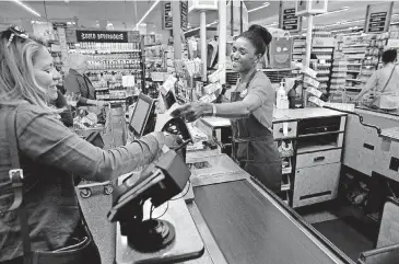  ?? [AP PHOTOS] ?? Nadine Vixama, who emigrated from Haiti eight years ago, works as a cashier at a Whole Foods in Cambridge, Mass. Vixama has taken English classes and a program in store and customer service basics developed by the National Retail Federation trade group...